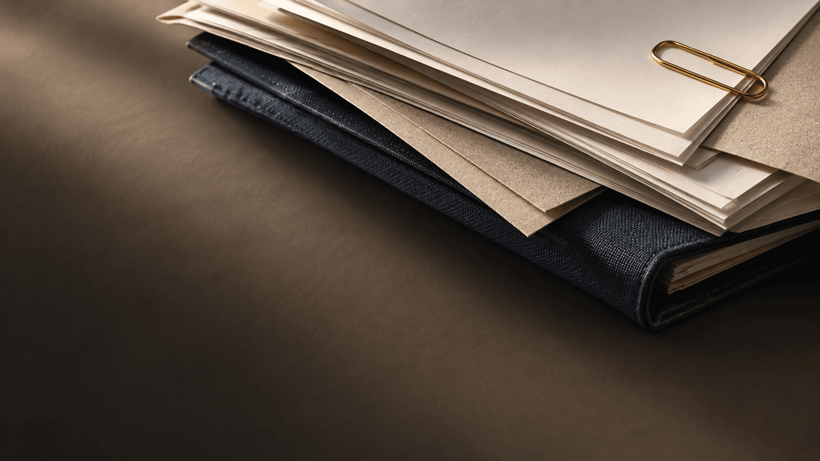 Dossier de factures et pièces soigneusement rangées sur un carnet bleu